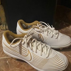 Never worn Nike cleats in white and gold. Size 10 in women shoes.